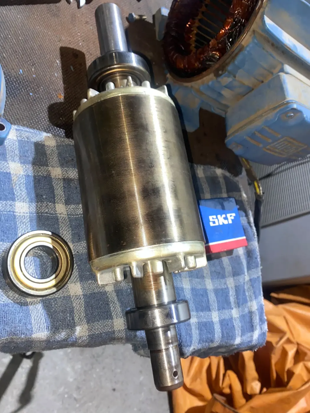 Rotor do motor aberto ao lado de um rolamento novo na caixa